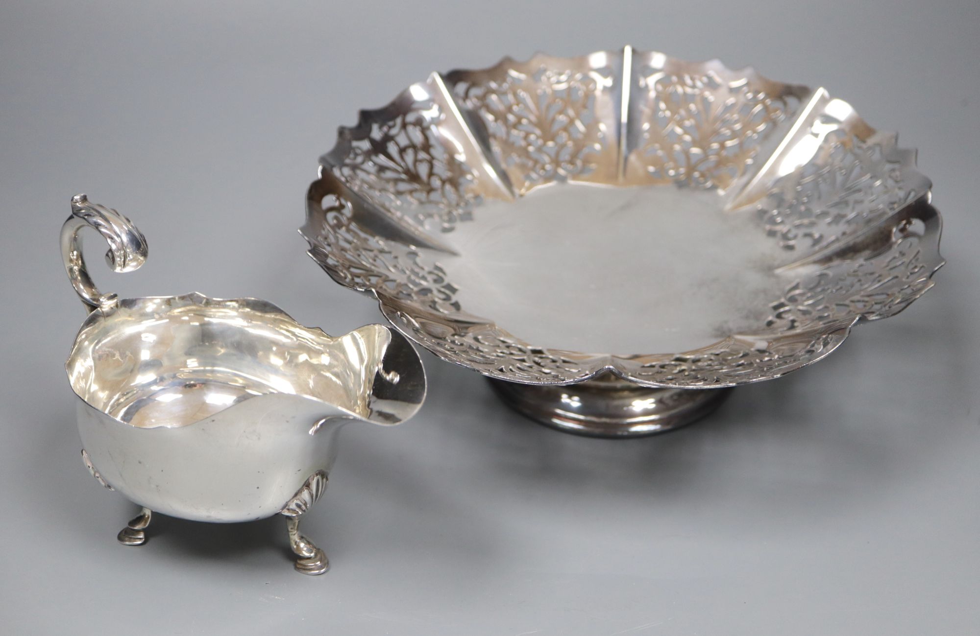 A George V silver sauceboat, Sheffield, 1917, 60z and a plated stand.